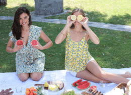 comment s'habiller pour une sortie entre copines ? duo mannequins assises sur une nappe de pique-nique en vêtements imprimés agrumes et pamplemousses et citrons dans les mains