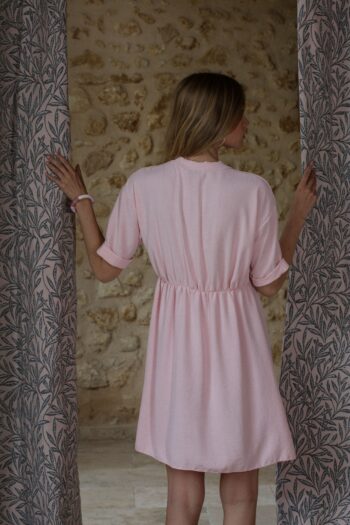 Photo shooting blonde model with pale pink empire cutout dress from the back