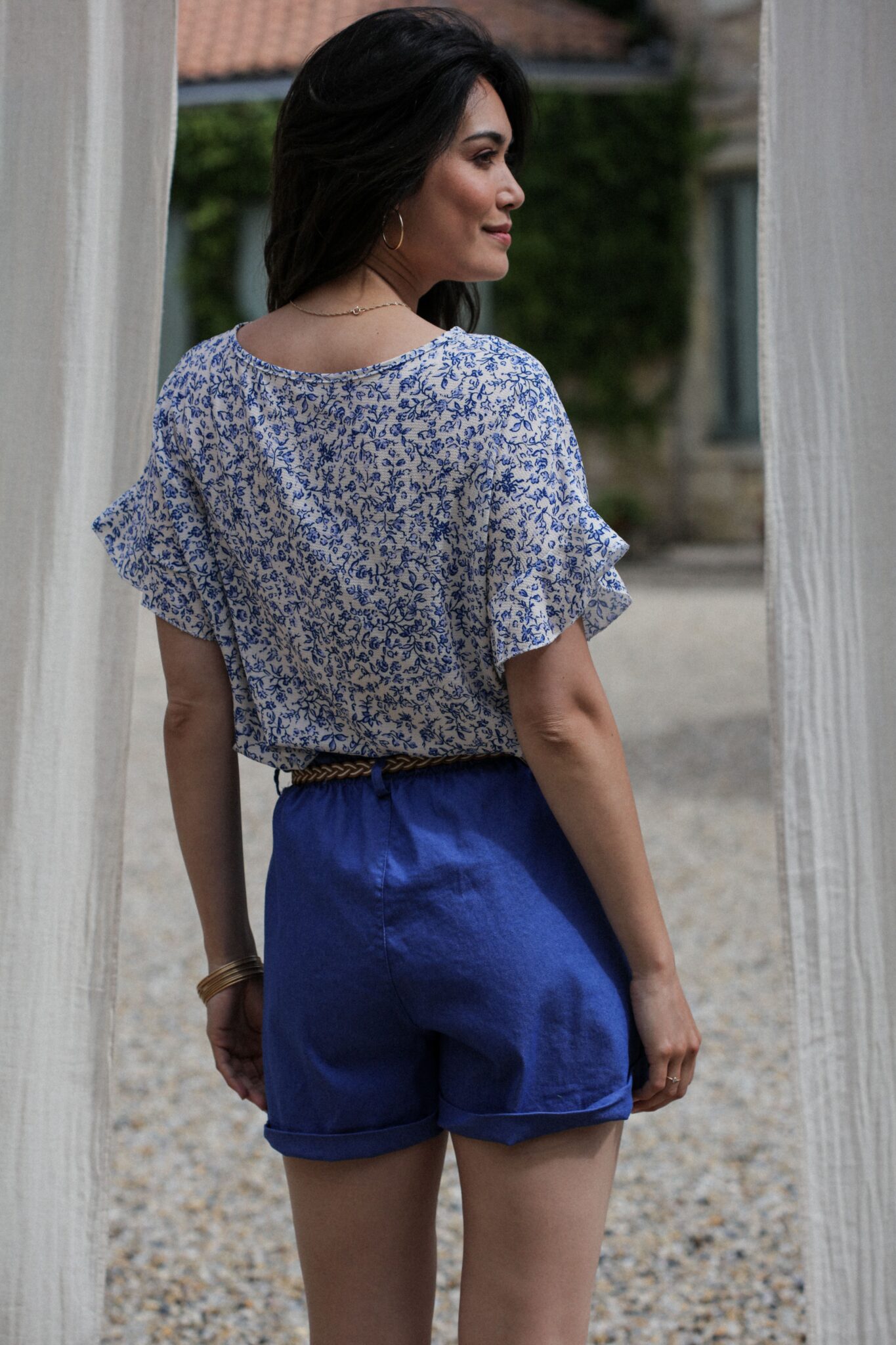 Shooting model wearing current blouse printed pinks blue sleeves short back sleeves