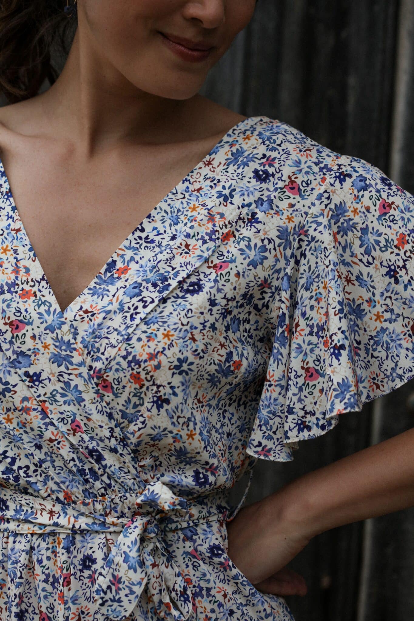 Shooting model wearing our floral jumpsuit Butterfly sleeves blue jeans current zoomed