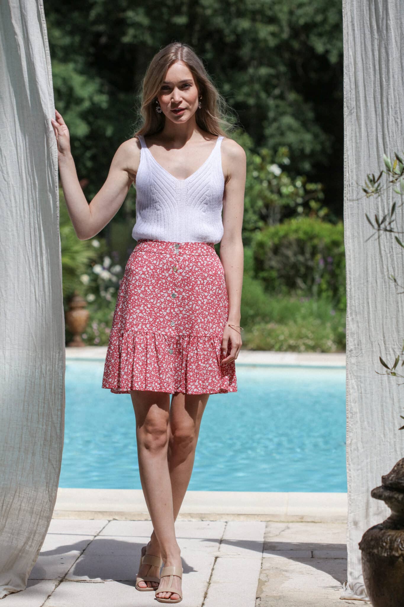 shooting au bord de la piscine mannequin avec jupe courte fleurie bicolore rouge et top tricot blanc 2