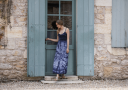 les idées reçues à oublier / modèle portant robe longue crochet imprimé tie and dye bleu marine devant une porte d'entrée